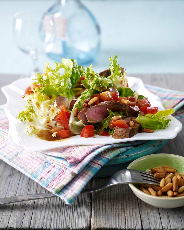 Frisée-Römersalat mit Beefsteak, Tomaten, Pinienkernen und Balsamico ...