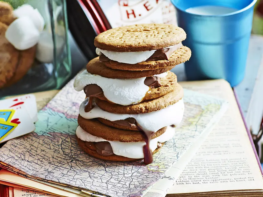 Gestapelte S’mores aus runden Keksen, mit gegrillten, geschmolzenen Marshmallows und zartschmelzender Schokolade.