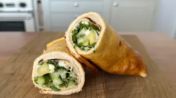 Aufgeschnittener Wrap mit cremiger Frischkäsefüllung, Avocado, Gurke und Salat auf einem Holzbrett in einer Küche. - Foto: LECKER @ Bauer Media Group / Anne Kurz Aufgeschnittener Wrap mit cremiger Frischkäsefüllung, Avocado, Gurke und Salat auf einem Holzbrett in einer Küche. - Foto: LECKER @ Bauer Media Group / Anne Kurz