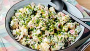 7-Tassen-Salat mit Schnittlauch in einer großen blauen Servierschüssel mit schwarzem Servierbesteck - Foto: House of Food / Bauer Food Experts KG
