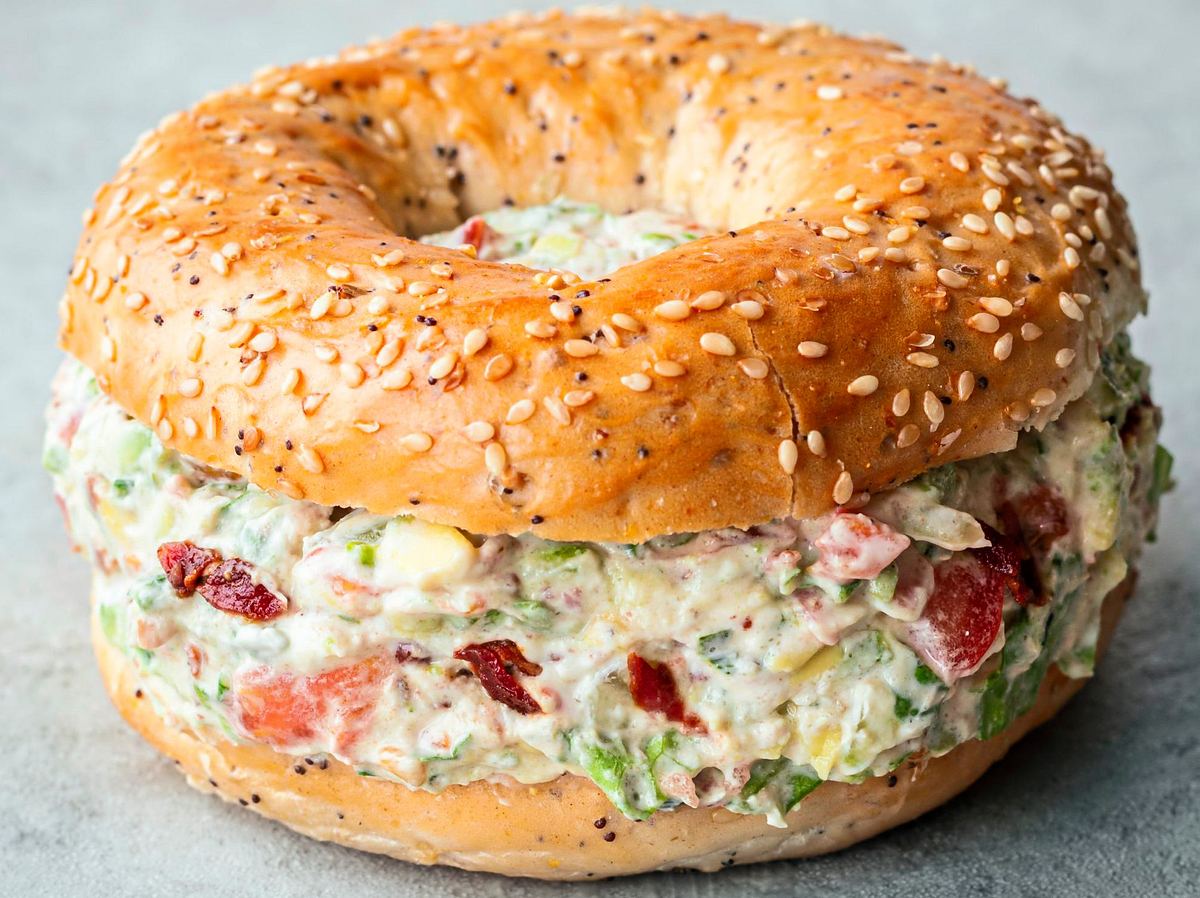Sesambagel gefüllt mit cremiger Mischung aus Bacon, Tomaten und Salat im BLT-Style