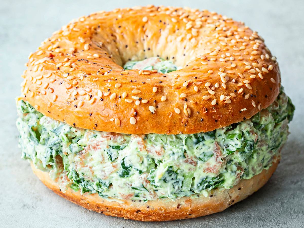 Sesambagel gefüllt mit cremigem Lachs-Spinat-Dip im skandinavischen Stil