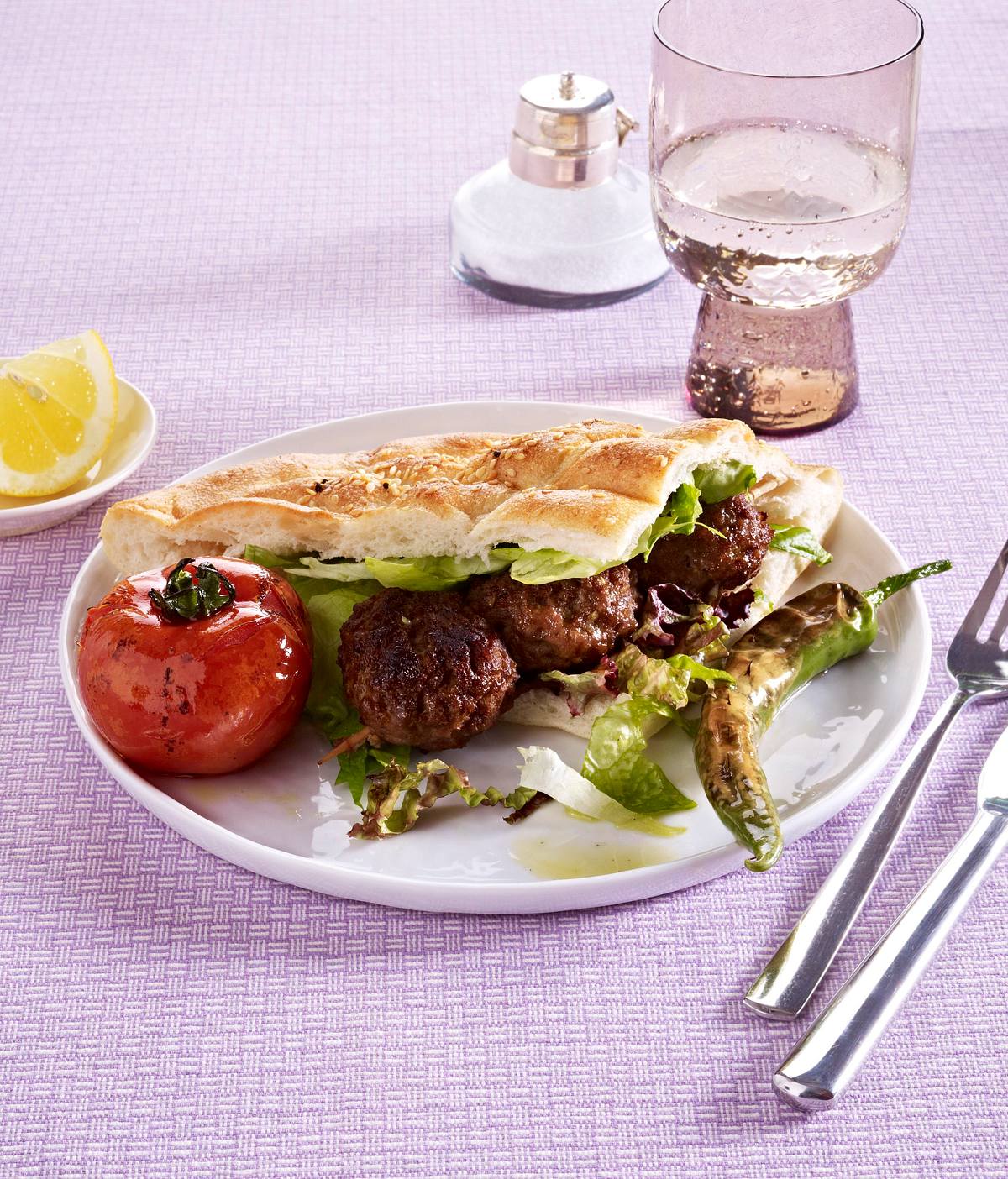 Adana Kebab auf Fladenbrot und Salat Rezept