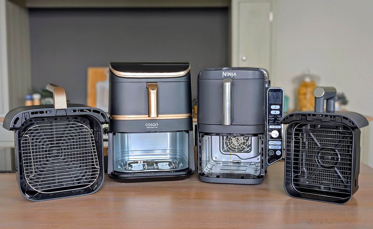 Der Cosori Turbo Tower Pro Smart steht neben dem Ninja Double Stack XL auf einer Arbeitsfläche, mit jeweils einer senkrecht aufgestellten Schublade neben den Geräten.