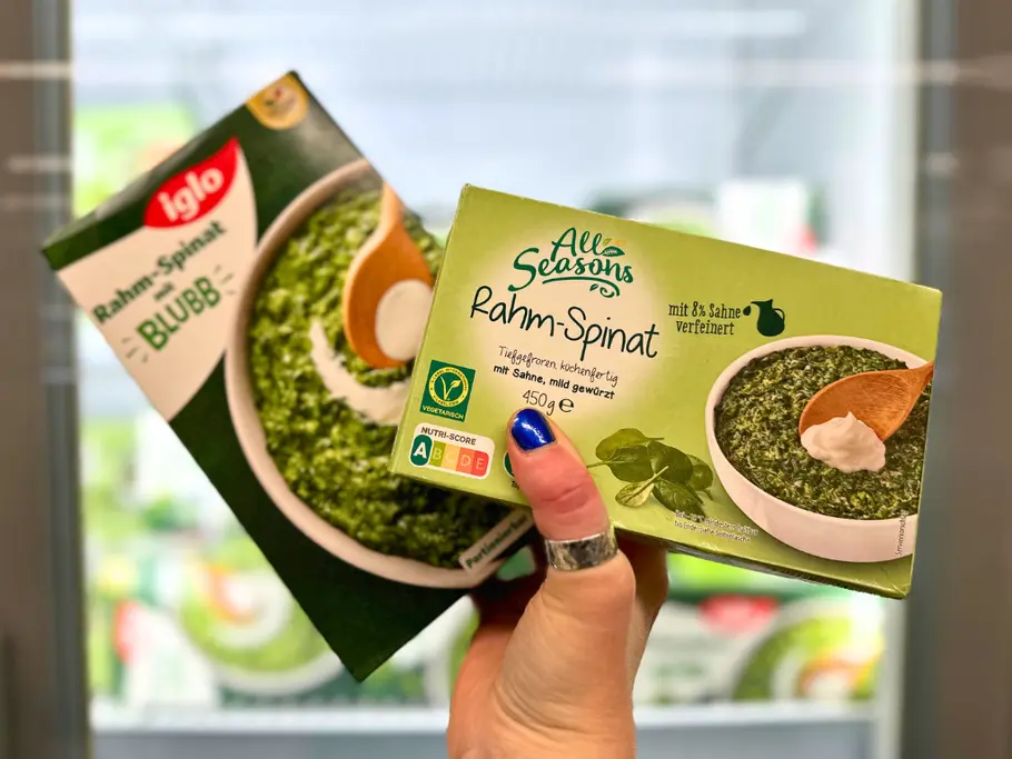 Eine Hand hält eine Packung All Seasons Rahm-Spinat und eine Packung Rahm-Spinat mit Blubb von Iglo