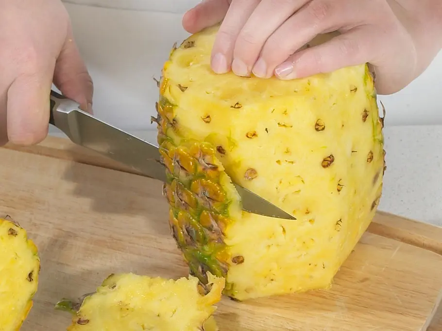 Ananas schälen Eine Ananas wird mit einem Messer geschält.