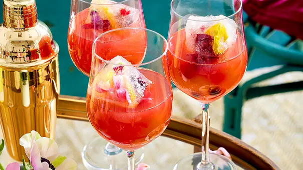 Aperitif: Aperol-Mimosa in Stielgläsern mit Blumen-Eiswürfeln. - Foto: LECKER @ Bauer Media Group