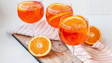 Aperol Spritz in drei Weingläsern mit Orangenscheiben und Eiswürfeln. - Foto: ShowHeroes für LECKER.de Aperol Spritz in drei Weingläsern mit Orangenscheiben und Eiswürfeln. - Foto: ShowHeroes für LECKER.de