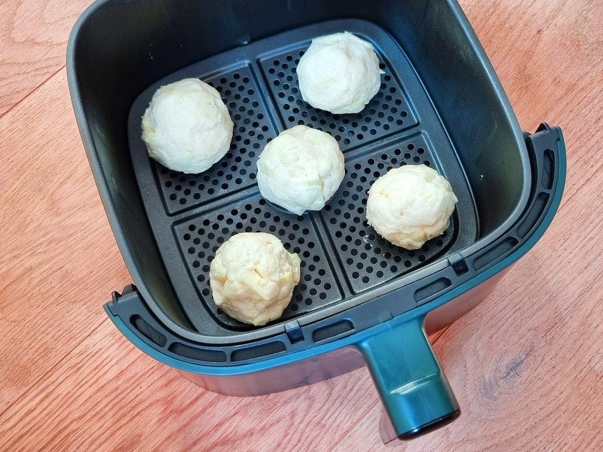 Apfelbällchen in Heißluftfritteuse Rezept Die rohen Apfelbällchen befinden sich im Garkorb der Heißluftfritteuse.