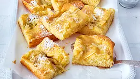 Apfelmuskuchen vom Blech ist in Stücke geschnitten und leicht mit Puderzucker bestäubt. - Foto: LECKER @ Bauer Media Group