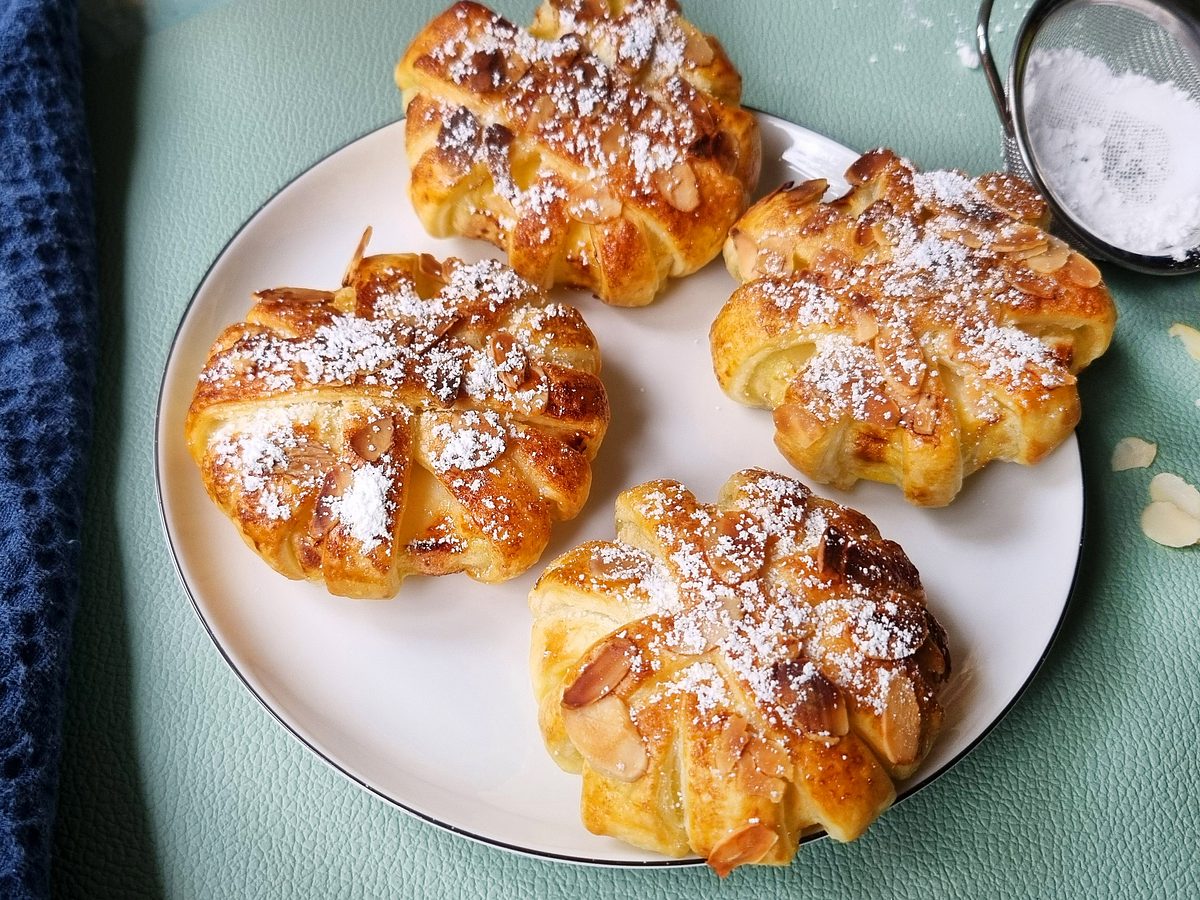Goldbraun gebackene Apfelringe aus dem AIrfryer sind mit wenig Puderzucker bestäubt.