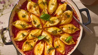 Gefüllte Pasta-Muscheln in einer runden Auflaufform, gefüllt mit cremiger Zitronen-Ricotta-Mischung, serviert auf einer Schicht Tomatensauce und garniert mit grünem Pesto und frischem Basilikum. - Foto: ITA Assolatte Gefüllte Pasta-Muscheln in einer runden Auflaufform, gefüllt mit cremiger Zitronen-Ricotta-Mischung, serviert auf einer Schicht Tomatensauce und garniert mit grünem Pesto und frischem Basilikum. - Foto: ITA Assolatte