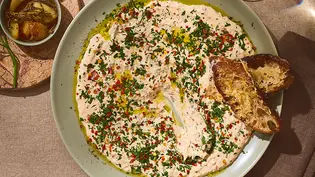 Cremiger Knoblauch-Dip mit Olivenöl, frischen Kräutern und Parmigiano Reggiano, serviert auf einem runden Teller mit knusprigem Brot. - Foto: ITA Assolatte Cremiger Knoblauch-Dip mit Olivenöl, frischen Kräutern und Parmigiano Reggiano, serviert auf einem runden Teller mit knusprigem Brot. - Foto: ITA Assolatte