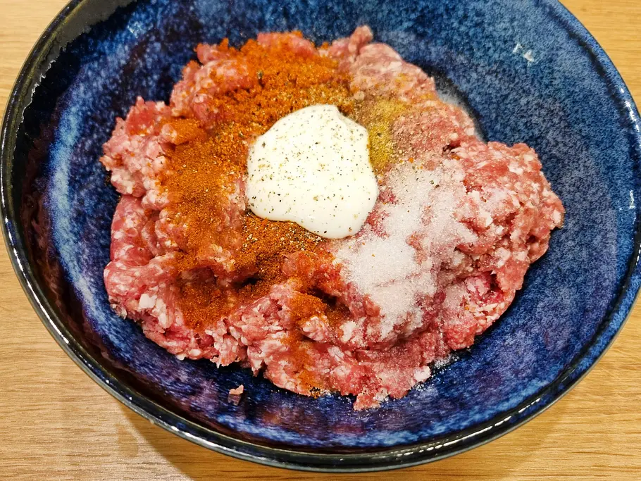 Zutaten für den Backpapier-Döner. Gewürze, Joghurt und Fleisch für den Backpapierdöner in einer Schüssel.