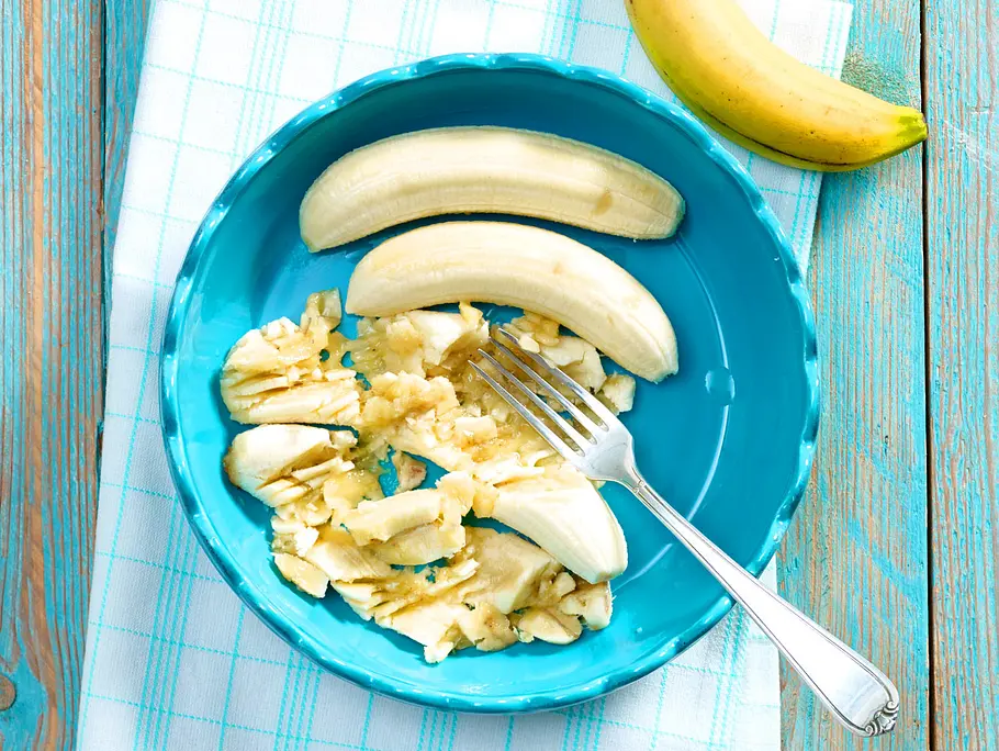 Bananen für Bananenbrot mit einer Gabel zerdrücken Bananen mit einer Gabel zerdrücken