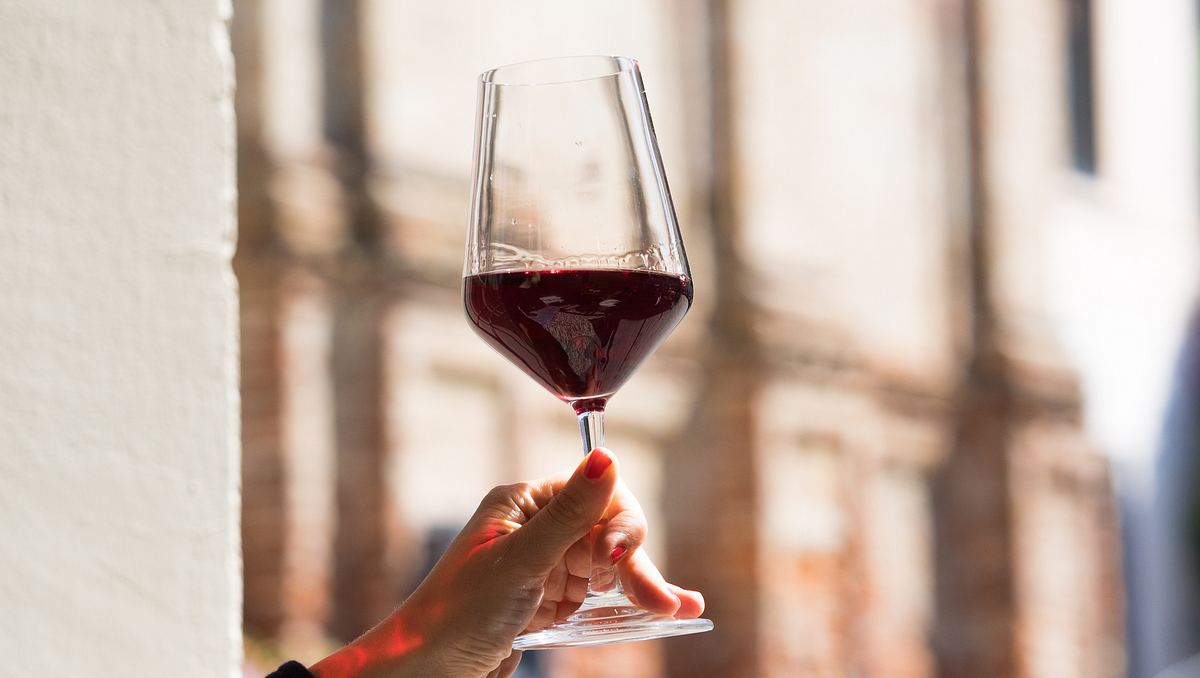 Frau hält Glas mit Barolo-Wein in der Hand