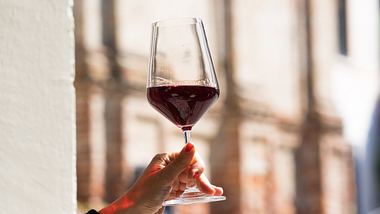 Frau hält Glas mit Barolo-Wein in der Hand - Foto: iStock/rattodisabina