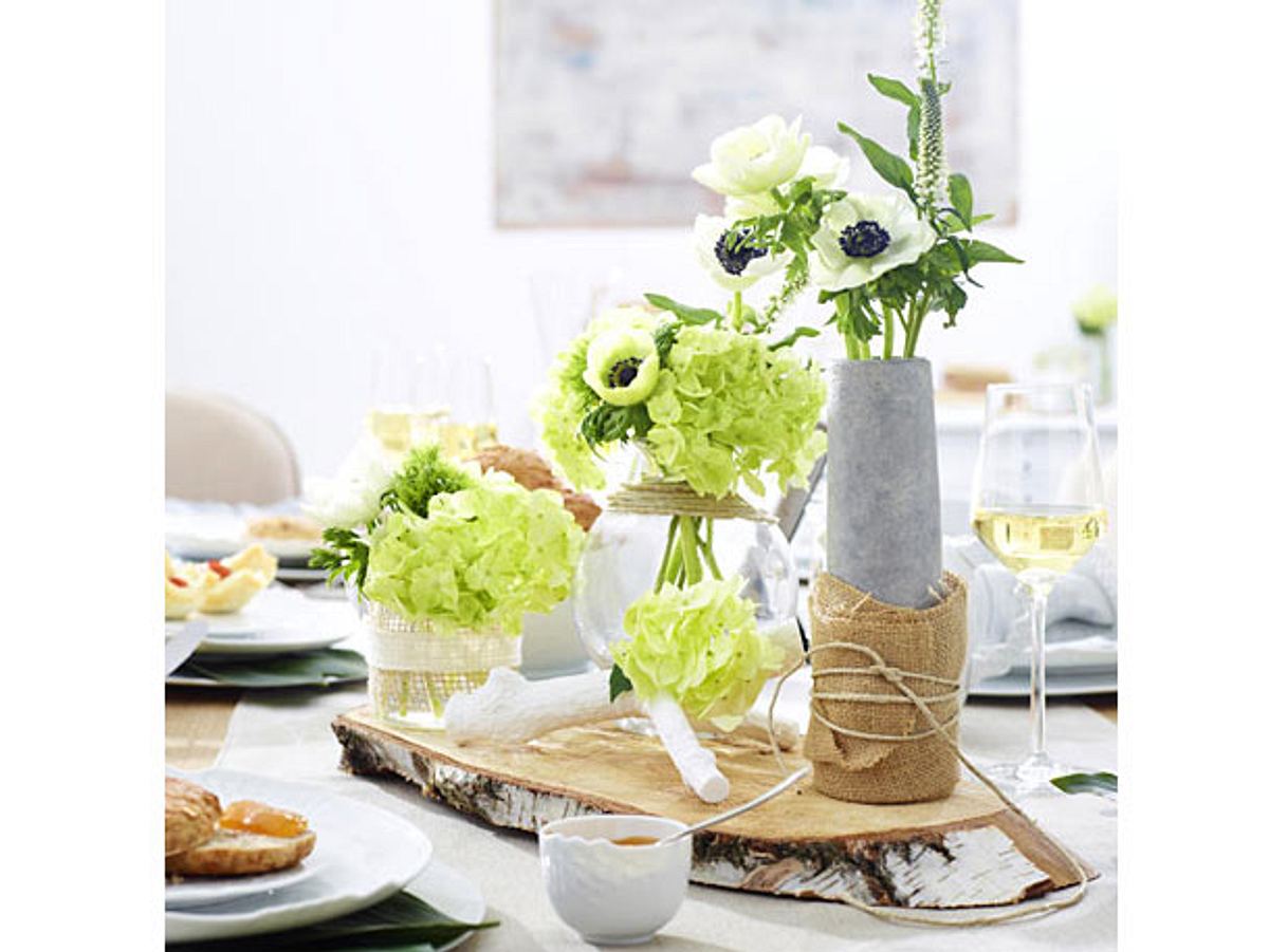 Schöne Tischdeko mit Baumscheibe und Blumen