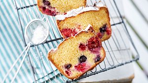 Vom Beeren-Kastenkuchen sind zwei Stücke abgeschnitten. Beeren wie Heidelbeeren und Himbeeren sind zu erkennen. - Foto: House of Food / Bauer Food Experts KG