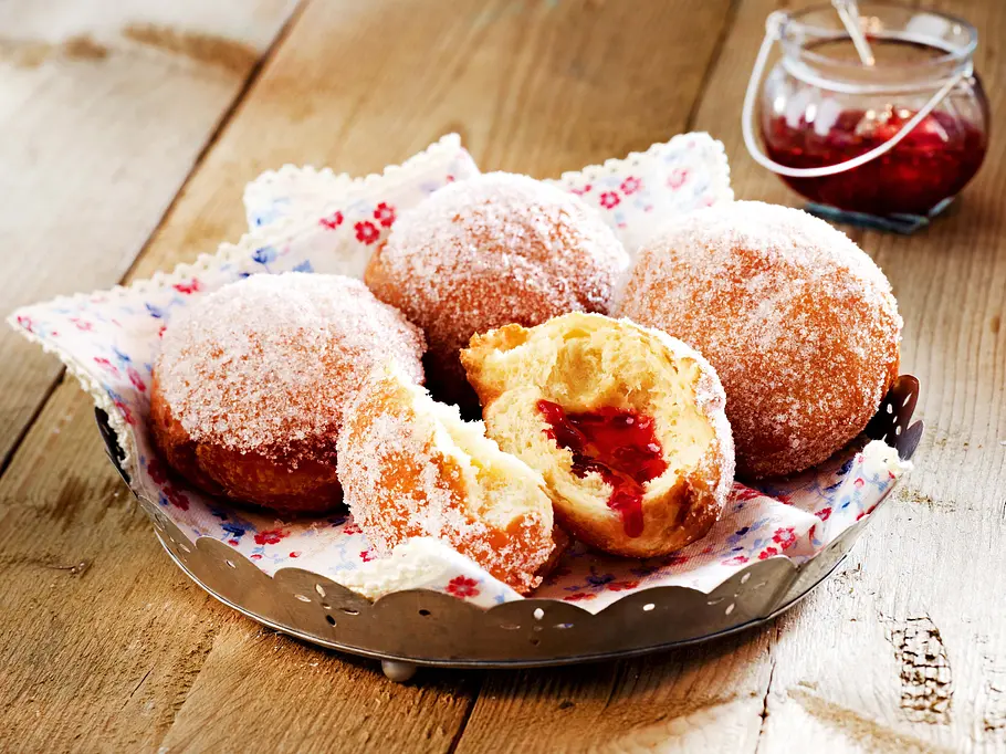 Berliner aus dem Airfryer: Ein Krapfen ist gefüllt und die Marmeladenfüllung kommt zum Vorschein.