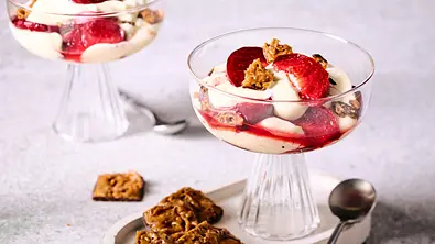Bienenstich-Dessert mit cremiger Schicht, frischen Pflaumenstücken und knusprigen Mandelkeksen in eleganten Glasschalen, serviert auf hellem Untersetzer mit Löffel und zusätzlichem Gebäck. - Foto: LECKER @ Bauer Media Group Bienenstich-Dessert mit cremiger Schicht, frischen Pflaumenstücken und knusprigen Mandelkeksen in eleganten Glasschalen, serviert auf hellem Untersetzer mit Löffel und zusätzlichem Gebäck. - Foto: LECKER @ Bauer Media Group