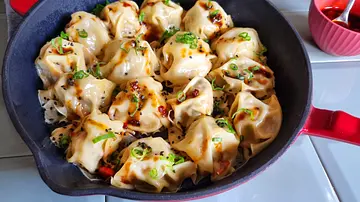 Blanket Dumplings in der Pfanne mit schwarzem Sesam und Frühlingszwiebeln garniert. - Foto: LECKER @ Bauer Media Group / Max Bergmann Blanket Dumplings in der Pfanne mit schwarzem Sesam und Frühlingszwiebeln garniert. - Foto: LECKER @ Bauer Media Group / Max Bergmann