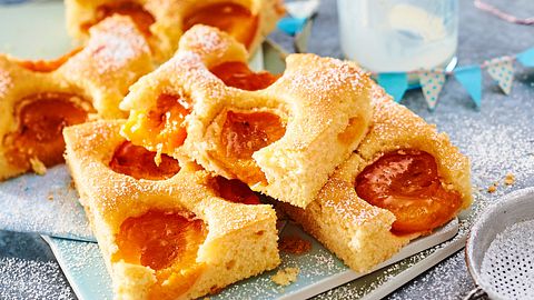 Bitzschneller-Becher-Kuchen mit Aprikosenhälften und Puderzucker auf einer Platte - Foto: House of Food / Bauer Food Experts KG