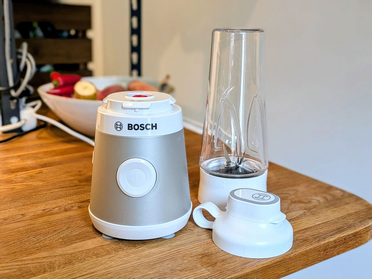 Bosch Smoothie-Maker VitaPower Serie 2 r Bosch VitaPower Serie 2 Smoothie-Maker steht mit leerem Mixbecher und Deckel auf einer Küchenanrichte.