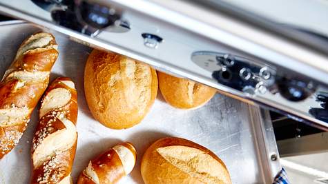 Brötchen aufbacken - so gehts richtig: Weizenbrötchen und Laugenstangen in den Ofen schieben - Foto: House of Food / Bauer Food Experts KG
