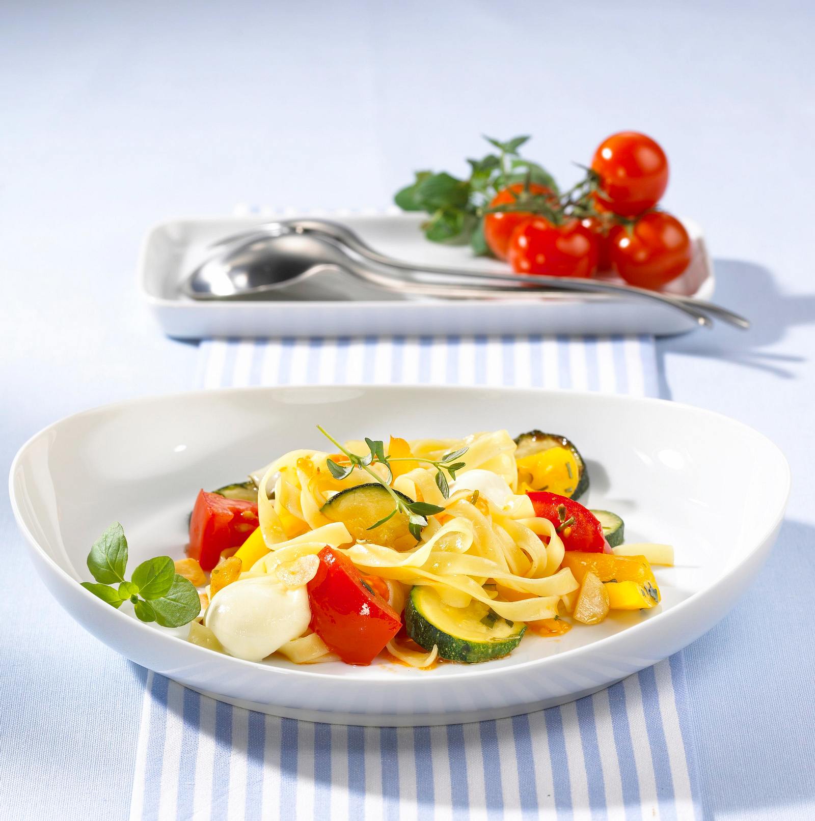 Bunte Nudelpfanne mit Zucchini, Tomaten, Mozzarellakugeln und Kräutern ...