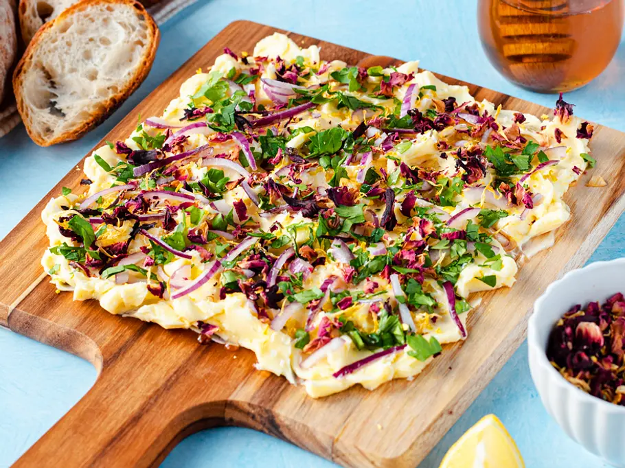 Butter-Board mit Kräutern Butter-Board mit Kräutern, roten Zwiebeln und Honig sieht nach Frühling aus.