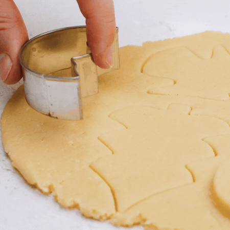 Butterplätzchen werden mit einem Ausstecher in Mond-Form ausgestochen.