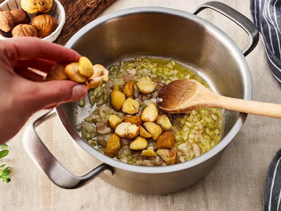 Maronensuppe Rezept In einen Kochtopf mit gedünsteten Zwiebeln werden grob gehackte Maronen gegeben