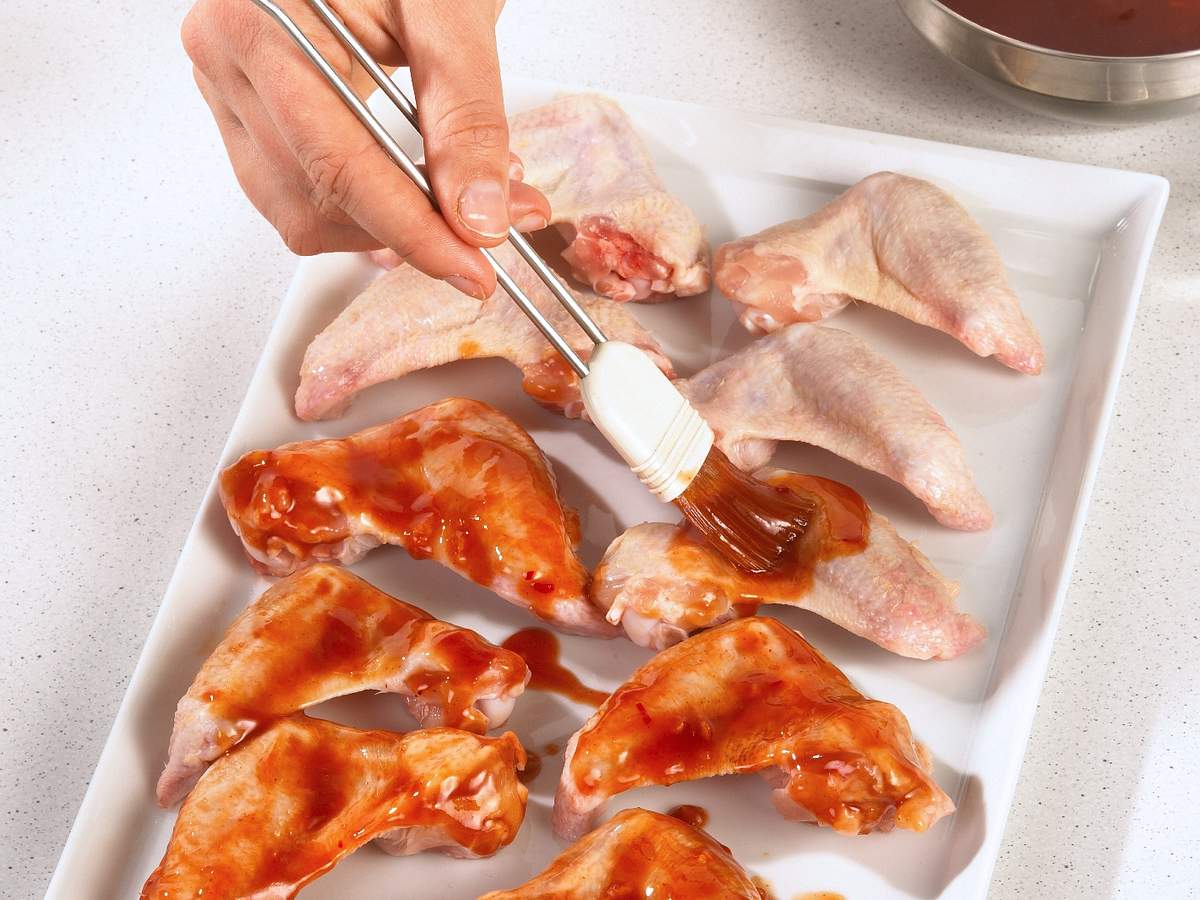 Chicken Wings mit Marinade bestreichen