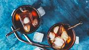 Zwei Gläser Cold Brew Coffee mit Strohhalm auf blauem Untergrund - Foto: iStock / OlegKov