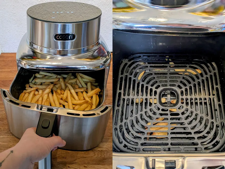 Im Garkorb der Cosori Iconic Heißluftfritteuse liegen Pommes, daneben ist der leere Garkorb der Heißluftfritteuse mit ein paar Pommes unter dem Gitter zu sehen.
