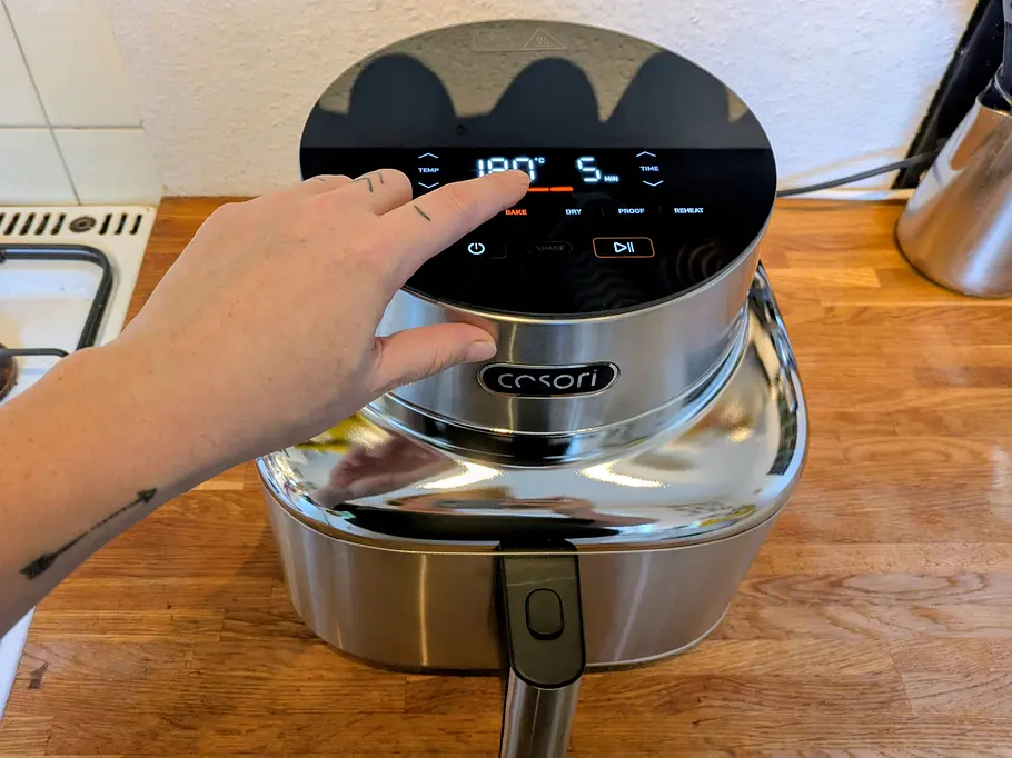 Eine Hand bedient das Display des Cosori Iconic Single Airfryers.