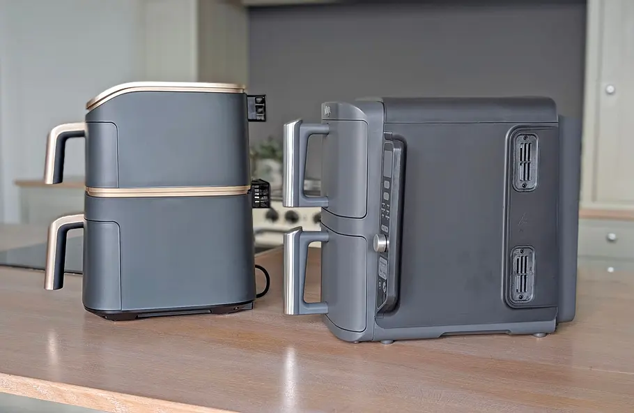 Der Cosori Turbo Tower Pro Smart und der Ninja Double Stack XL stehen nebeneinander auf einer Arbeitsfläche und sind jeweils von der Seite zu sehen. Der Double Stack ist deutlich länger als der Turbo Tower.