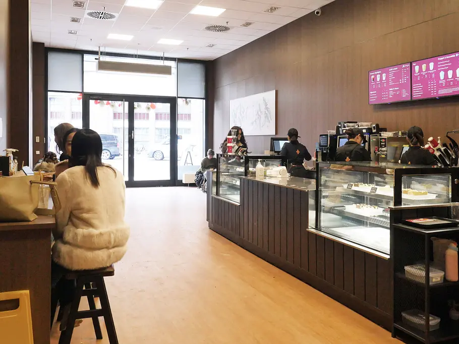 Cotti Coffee in Berlin, Innenansicht Cotti Coffee-Store in Berlin, mit Kaffeebar und Sitzplätzen.