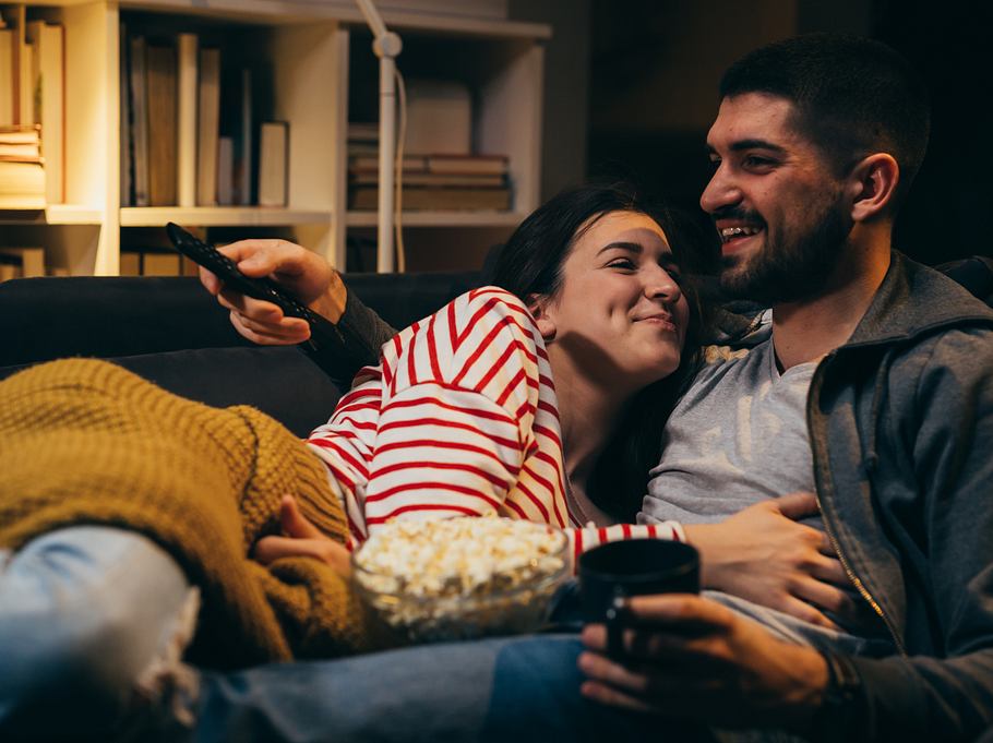 Junges Paar beim Filmabend auf dem Sofa.
