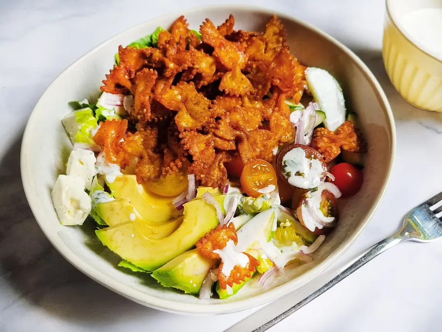 Sommer-Salat mit Crunchy Pasta Eine Schüssel mit Salat, getoppt von goldbraunen knusprigen Farfalle-Nudeln.