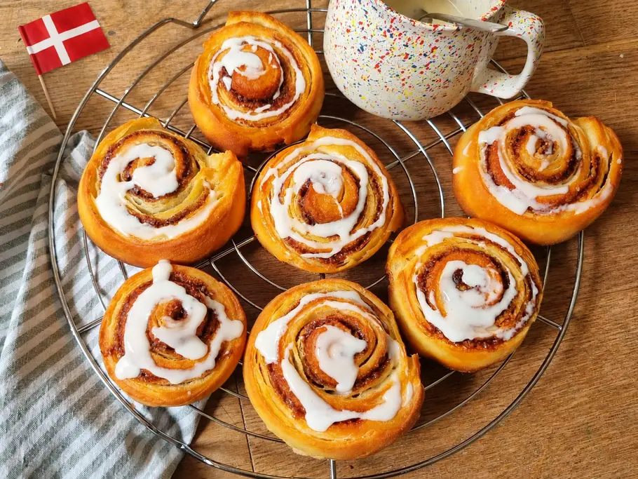 Dänische Zimtschnecken Rezept Zimtschnecken mit Zuckerguss auf einem Abkühlgitter.