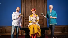 Enie van de Meiklokjes steht mit den Juroren Christian Hümbs und Bettina Schliephake-Burchardt bei „Das große Promibacken“ und hält gemeinsam mit ihnen Kuchen in der Hand. - Foto: SAT.1 / Claudius Pflug