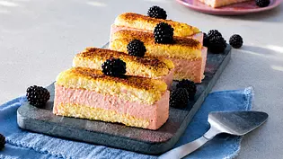 Brombeer-Puddingschnitten mit frischen Brombeeren verziert liegen auf einer grauen Kuchenplatte. Darunter ein blaues Tuch und daneben ein silberner Kuchenheber. - Foto: Muench, Katja/LECKER @ Bauer Media Group Brombeer-Puddingschnitten mit frischen Brombeeren verziert liegen auf einer grauen Kuchenplatte. Darunter ein blaues Tuch und daneben ein silberner Kuchenheber. - Foto: Muench, Katja/LECKER @ Bauer Media Group
