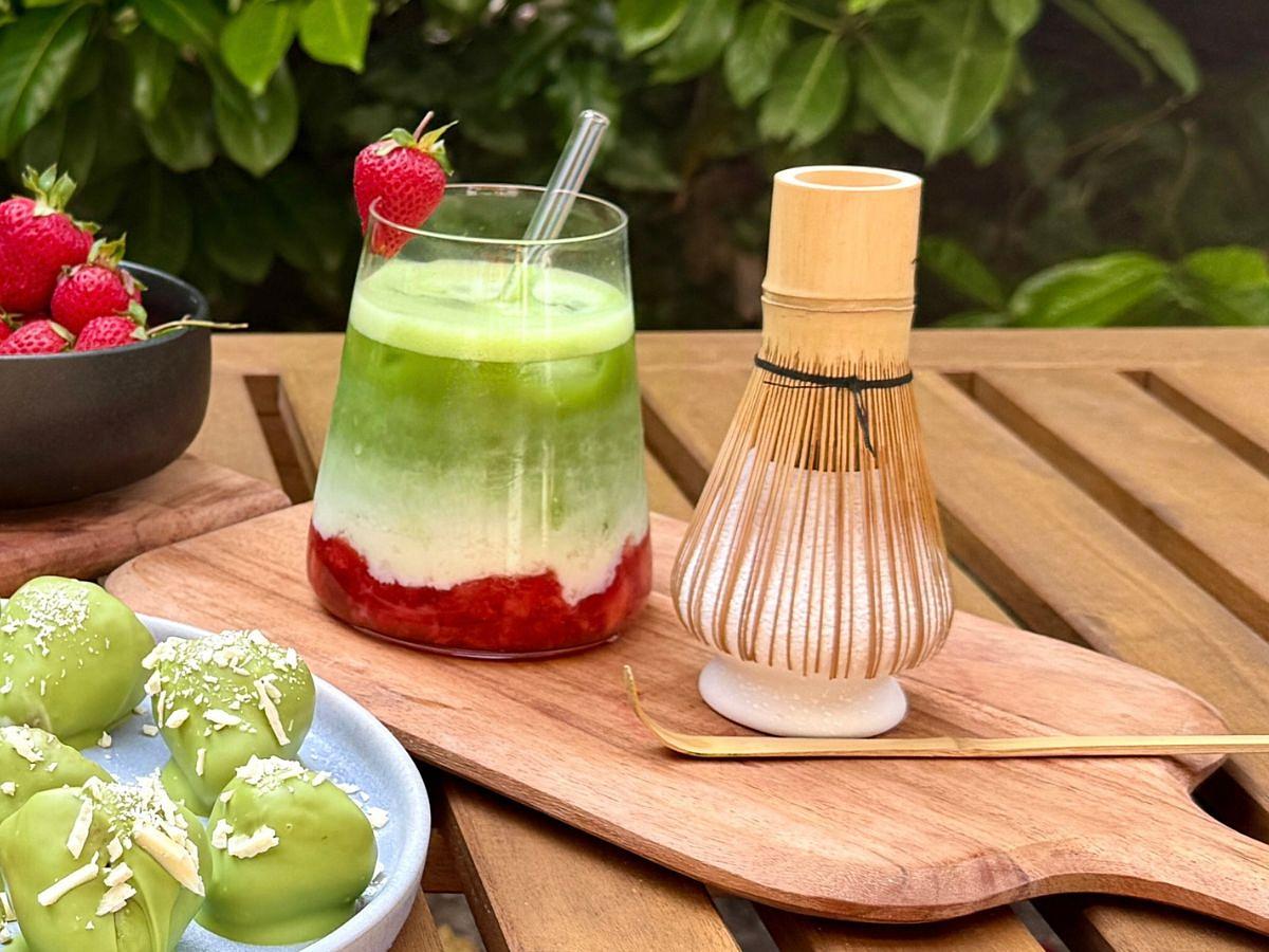 Ein Matcha Latte im Glas mit einem Chasen-Besen