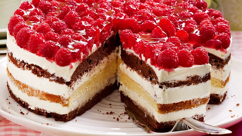 Die Drei-Tage-Torte besteht aus zwei dunklen Tortenböden und einem hellen. Dazwischen befindet sich Vanillesahne. Gekrönt wird sie von Himbeeren. - Foto: House of Food / Bauer Food Experts KG