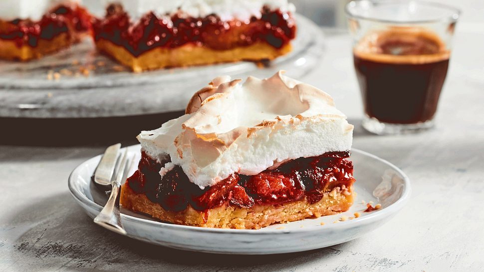 Pflaumen-Baiser-Kuchen mit Mürbeteig auf einem kleinen Teller mit Kuchengabel - Foto: House of Food / Food Experts KG