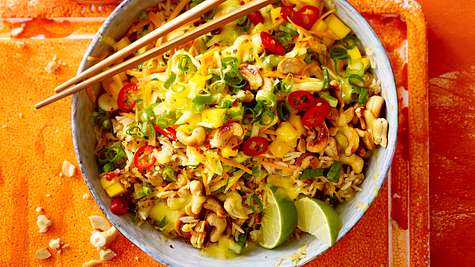 Bratreissalat mit Mango und Limettenspalten in einer Schüssel mit Stäbchen - Foto: House of Food / Bauer Food Experts KG