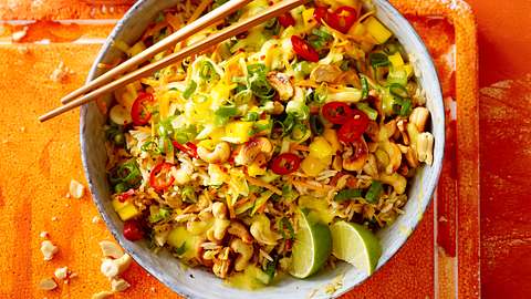 Bratreissalat mit Mango und Limettenspalten in einer Schüssel mit Stäbchen - Foto: House of Food / Bauer Food Experts KG