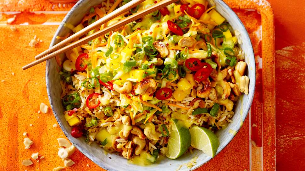 Bratreissalat mit Mango und Limettenspalten in einer Schüssel mit Stäbchen - Foto: House of Food / Bauer Food Experts KG